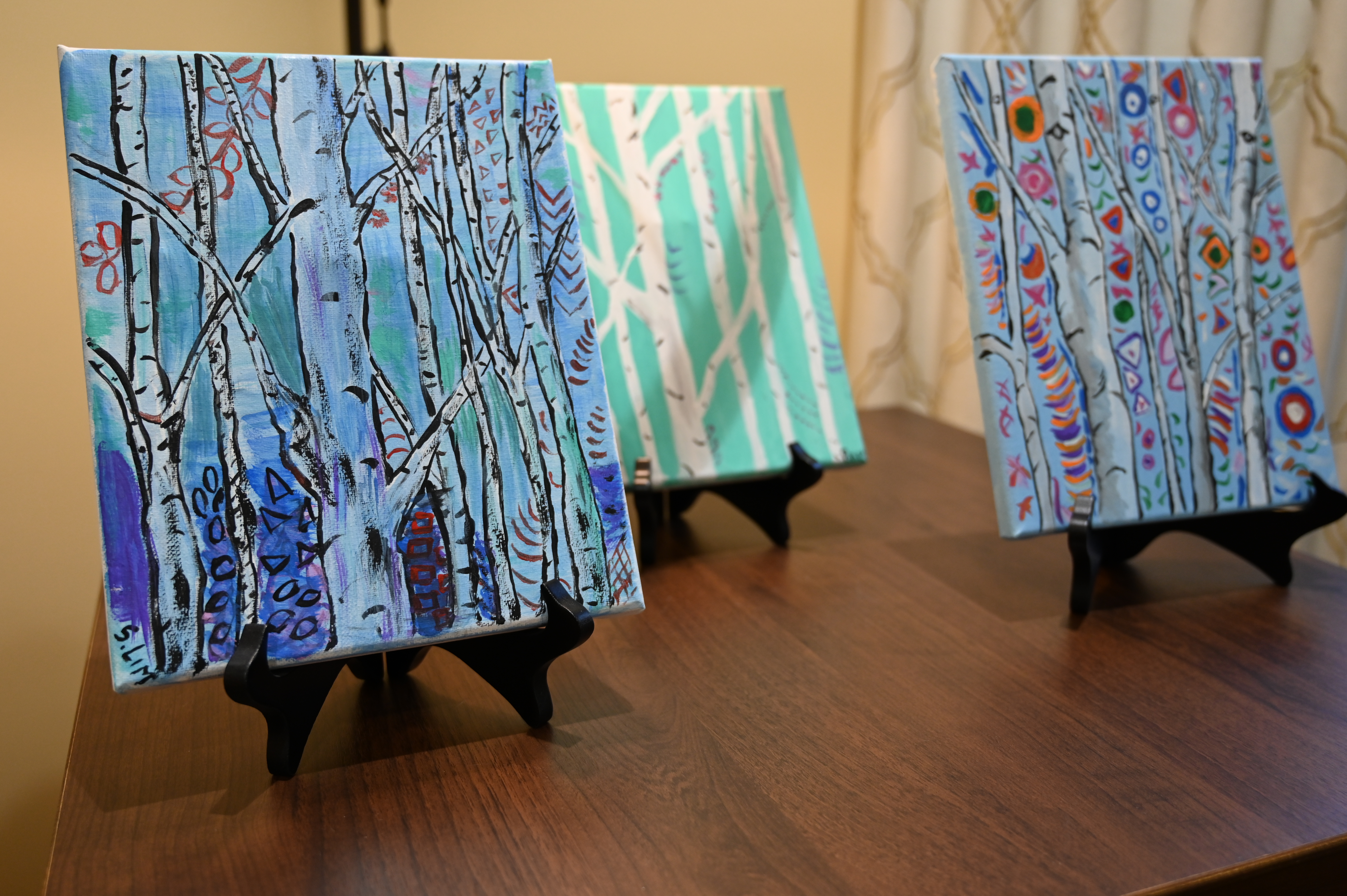 Three paintings displayed on a table at Brightview Mays Chapel Ridge