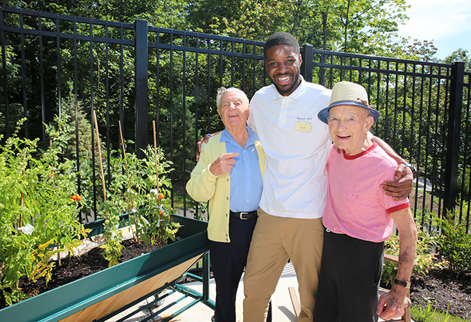 Wellspring Village Memory Care Residents enjoying outdoor patio and laughing with Brightview associate